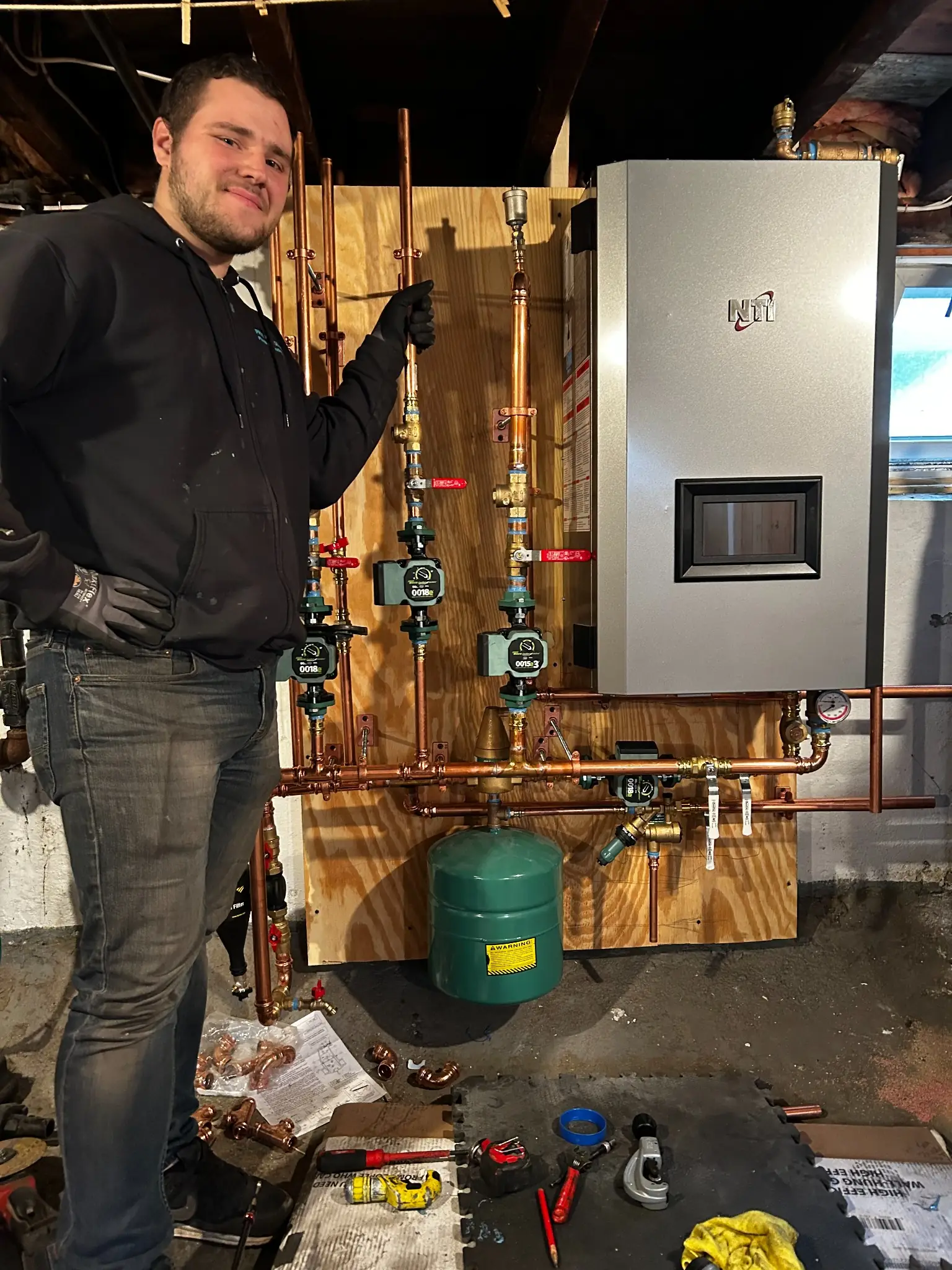 Technician installing a new NTI boiler and hydronic piping system