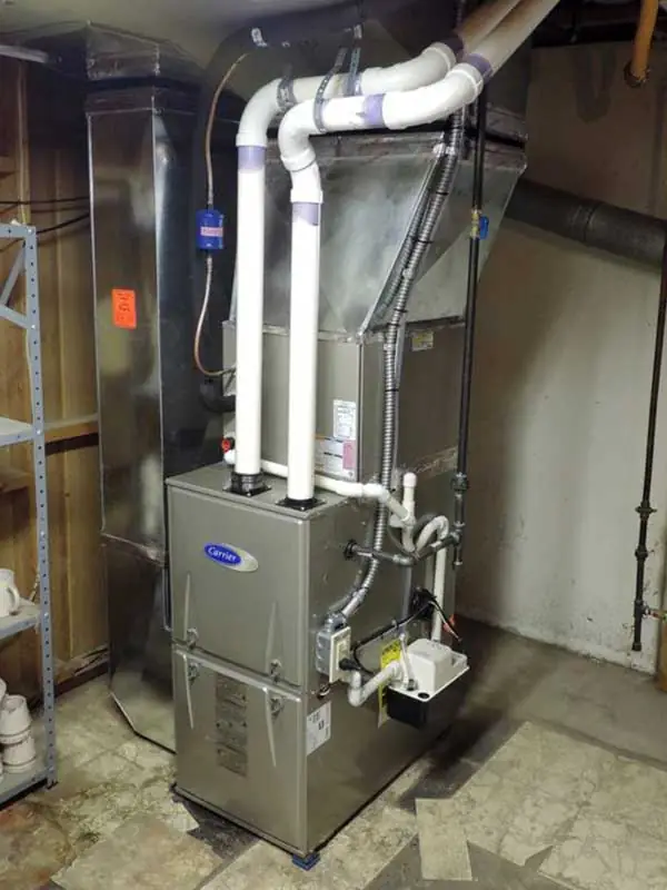 Newly installed Carrier gas furnace with venting and condensate piping in a basement