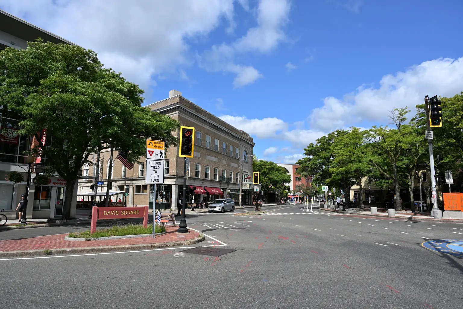 Davis Square in Somerville, MA with shops and street signage